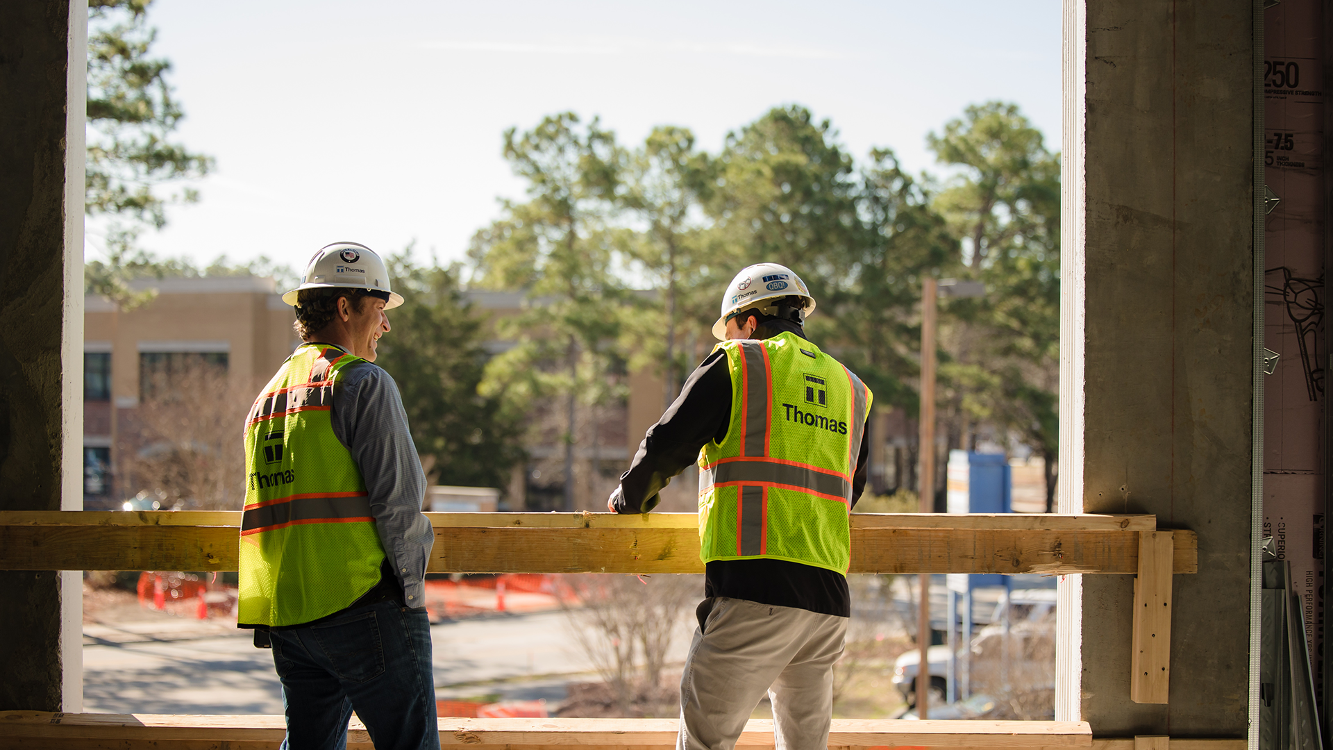 Two Thomas guys standing on a jobsite chatting